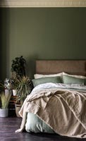 Country bedroom with dark green painted walls 