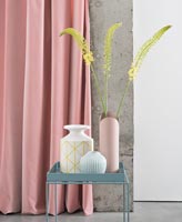 Collection of vases on side table in pastel colours 