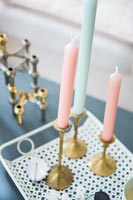 Pastel blue and pink candles on brass candlesticks 