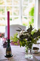 Candle and flowers on country dining table 