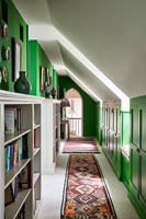 Bookshelves in green and white corridor 