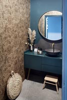 Blue painted bathroom with stone mosaic wall 
