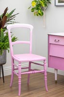Chair painted to create an ombre paint effect with various shades of pink