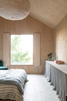 Timber clad modern country bedroom - hidden storage under fabric skirt 
