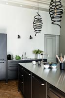 Modern kitchen with black spiral pendant lights over island 