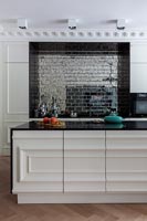 Large modern kitchen with island, tiled feature wall and period details 
