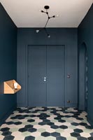 Modern hallway with dark grey painted walls and patterned flooring 