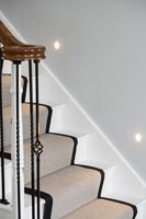 Classic staircase with runner carpet and spot lights