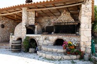 Stone barbecue and pizza oven on covered terrace