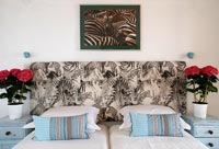 Modern bedroom zebra patterned headboard and photograph above bed 