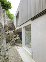 Contemporary house exterior next to rock face 