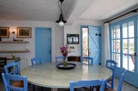 Blue painted chairs around circular wooden dining room 