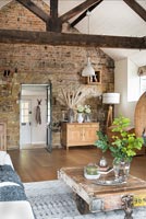 Exposed stone wall and beams in country living room 