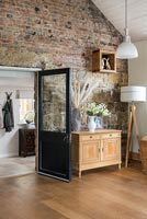 Wooden sideboard against exposed stone wall in country living room 