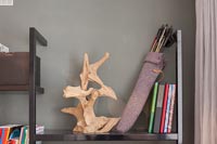Sculpture and quill filled with arrows on bookshelves 