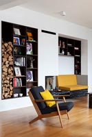 Modern living room with alcove shelving and firewood storage 