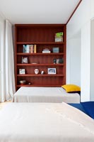 Twin beds and wooden bookcase in modern bedroom 