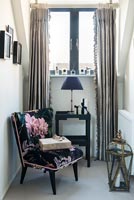 Floral armchair in tiny snug next to window 
