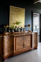 Vintage wooden sideboard with display of vases and gold painting 