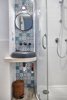 Decorative blue and white tiling behind modern sink 
