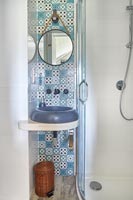 Decorative blue and white tiling behind modern sink 