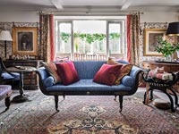 Classic living room with patterned wallpaper and antique furniture 