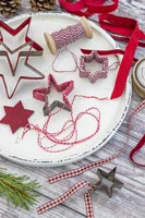 Metal cookie cutter covered with red and white string