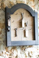 Vintage keys on hooks in wooden frame