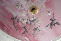 Pink painted mural on ceiling with chandelier detail 