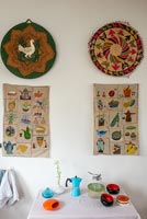 Decorative wall hangings above small table