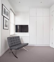 Grey leather sofa and wall mounted television in dressing room 