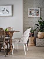 Patterned chair at head of modern dining table 