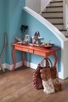 Small wooden console table at bottom of staircase 
