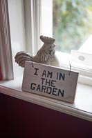 Wooden sign and chicken ornament on windowsill 