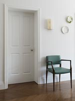 Teal coloured chair in modern hallway 