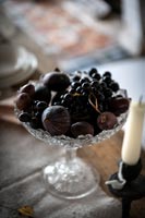 Dark coloured berries and figs in decorative glass bowl 