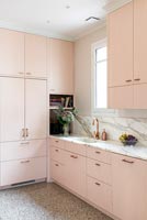 Modern pink kitchen with grey marble worktops 