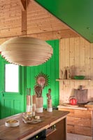 Modern country kitchen with green painted feature wall and ceiling 
