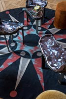 Circular patterned rug with unusual side tables 