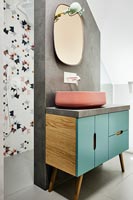 Teal and pink sink unit against concrete wall in modern bathroom 