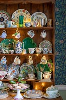 Display of colourful plates and crockery on wooden dresser 