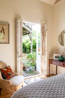 French doors open to garden in country bedroom 
