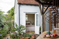 Exterior of white weatherboard country house with view into bedroom 