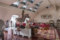 Eclectic living room with unusual triangular skylights 