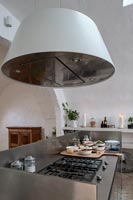 Extractor hood over large gas hob in modern country kitchen 