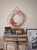 Lifebuoy on wall above distressed cabinet 