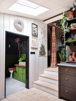 Country hallway with view into bright green painted bathroom 