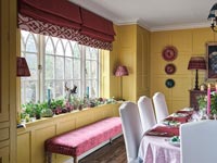 Pink seat next to window in classic dining room decorated for Christmas 