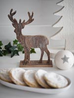 Carved reindeer Christmas ornament and mince pies 