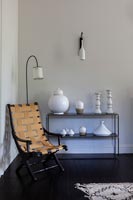 White ceramics on black side table and folding chair 